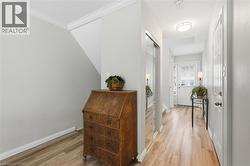 Hall featuring light wood-style floors and crown molding - 