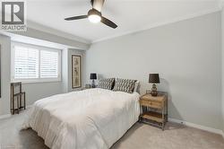 Bedroom featuring ornamental molding, light carpet, and a ceiling fan - 