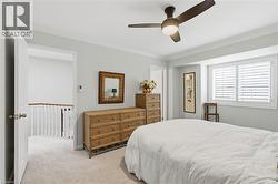 Bedroom with ornamental molding, light carpet, and a ceiling fan - 