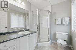 Full bathroom with a shower stall, vanity, and light tile patterned flooring - 