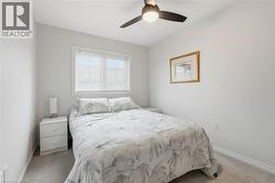 Bedroom featuring ceiling fan and light carpet - 