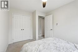 Bedroom featuring light carpet, ceiling fan, and a closet - 