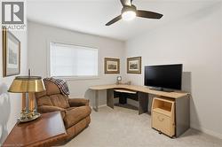 Office area with light colored carpet and ceiling fan - 