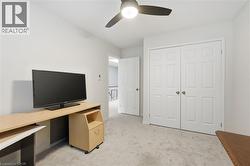 Office with light colored carpet and a ceiling fan - 