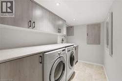 Laundry area with cabinet space, separate washer and dryer, and recessed lighting - 