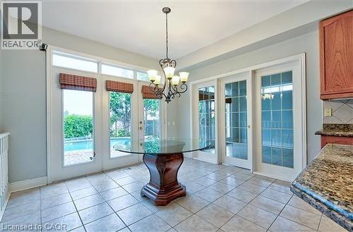 Unfurnished dining area featuring suspended lighting, light tile patterned flooring, and french doors - 2215 Tiger Road, Burlington, ON - Indoor Photo Showing Other Room