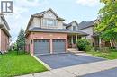 View of front facade featuring a garage, asphalt driveway, brick siding, a porch, and a front yard - 2215 Tiger Road, Burlington, ON  - Outdoor With Facade 