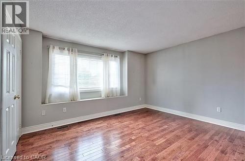 Unfurnished room with hardwood / wood-style flooring and a textured ceiling - 2215 Tiger Road, Burlington, ON - Indoor Photo Showing Other Room