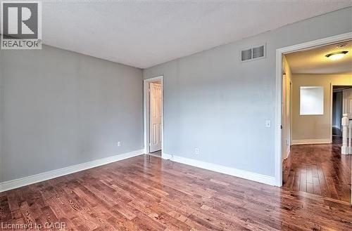 Empty room featuring dark wood-type flooring and baseboards - 2215 Tiger Road, Burlington, ON - Indoor Photo Showing Other Room