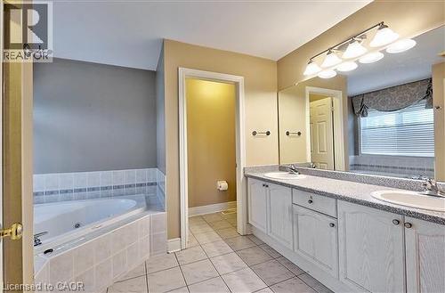 Full bath featuring a bath, double vanity, and light tile patterned floors - 2215 Tiger Road, Burlington, ON - Indoor Photo Showing Bathroom