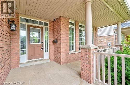 Property entrance featuring covered porch and brick siding - 2215 Tiger Road, Burlington, ON - Outdoor With Exterior