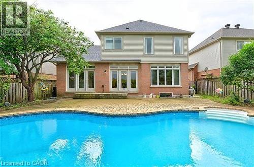 Rear view of property with a patio area, a fenced backyard, brick siding, and entry steps - 2215 Tiger Road, Burlington, ON - Outdoor With In Ground Pool