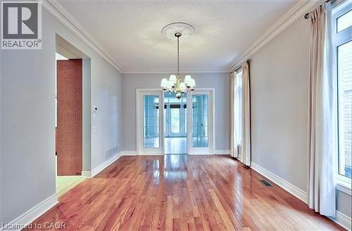 Unfurnished dining area featuring a chandelier, light wood finished floors, and crown molding - 2215 Tiger Road, Burlington, ON - Indoor Photo Showing Other Room