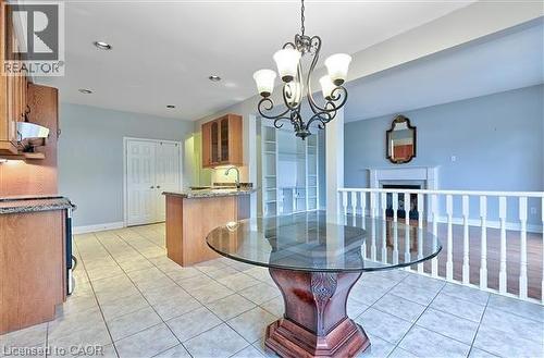 Dining area with suspended lighting, a fireplace, and light tile patterned floors - 2215 Tiger Road, Burlington, ON - Indoor