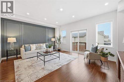 Living room with feature accent wall, abundant natural light, pot lighting and wood finished floors - 122 E Dundas Street E Unit# 9, Waterdown, ON - Indoor Photo Showing Living Room