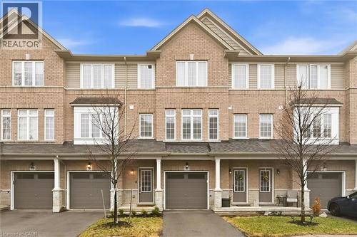 View of front of property featuring driveway, attached garage, and brick exterior. - 122 E Dundas Street E Unit# 9, Waterdown, ON - Outdoor With Deck Patio Veranda With Facade