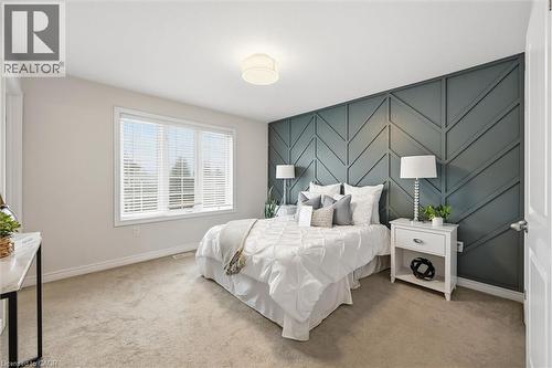 Primary bedroom with feature accent wall. - 122 E Dundas Street E Unit# 9, Waterdown, ON - Indoor Photo Showing Bedroom