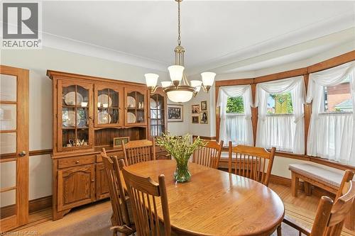 Dining room with a chandelier and light hard wood flooring - 98 Kensington Avenue S, Hamilton, ON - Indoor Photo Showing Dining Room