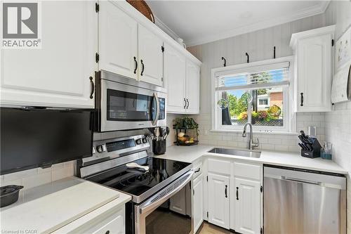 Kitchen featuring stainless steel appliances, white cabinets, backsplash, and crown molding - 98 Kensington Avenue S, Hamilton, ON - Indoor Photo Showing Kitchen
