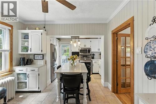 Kitchen featuring a breakfast bar, white cabinets,  and a kitchen island - 98 Kensington Avenue S, Hamilton, ON - Indoor