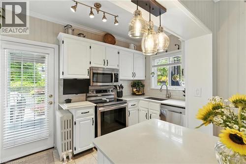 Kitchen with tasteful backsplash, white cabinetry, and ornamental molding - 98 Kensington Avenue S, Hamilton, ON - Indoor Photo Showing Kitchen