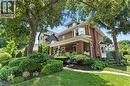 View of front facade featuring a porch, brick, and a front lawn - 98 Kensington Avenue S, Hamilton, ON  - Outdoor With Deck Patio Veranda 