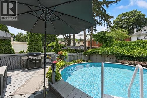 View of swimming pool with a deck, a fenced backyard, and grilling area - 98 Kensington Avenue S, Hamilton, ON - Outdoor With Above Ground Pool With Deck Patio Veranda