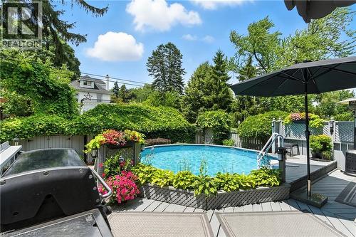 View of pool featuring a fenced backyard, a wooden deck, and area for grilling - 98 Kensington Avenue S, Hamilton, ON - Outdoor