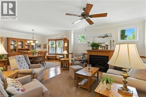 Living area featuring a glass covered fireplace, crown molding, and hardwood floors - 98 Kensington Avenue S, Hamilton, ON - Indoor Photo Showing Living Room With Fireplace