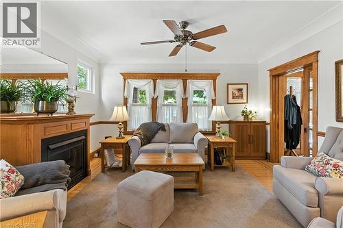 Living area with light  floors, ceiling fan, and an electric fireplace - 98 Kensington Avenue S, Hamilton, ON - Indoor Photo Showing Living Room With Fireplace