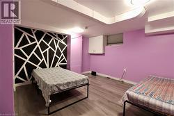 Bedroom with wood finished floors and an accent wall - 