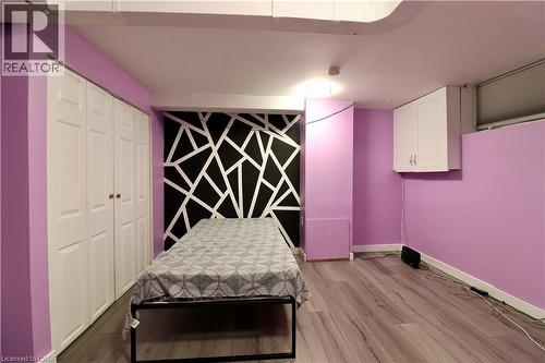Bedroom with light wood-type flooring, a closet, and an accent wall - 80 Roseview Avenue, Cambridge, ON - Indoor Photo Showing Bedroom