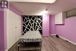 Bedroom with light wood-type flooring, a closet, and an accent wall - 