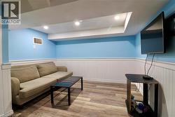 Living area featuring light wood-style flooring, a wainscoted wall, and recessed lighting - 