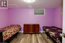 Bedroom with light wood-style flooring and attic access - 