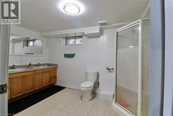 Full bathroom with double vanity, a shower stall, and dark tile patterned floors - 