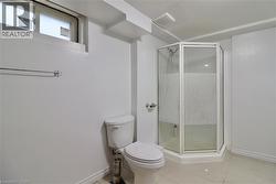 Bathroom with a shower stall and light tile patterned floors - 