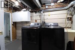 Laundry area featuring finished concrete flooring and separate washer and dryer - 