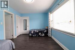 Bedroom with dark wood finished floors and a closet - 