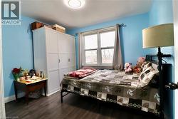 Bedroom with a closet and dark wood-style floors - 