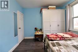 Bedroom featuring baseboards and dark wood-style floors - 