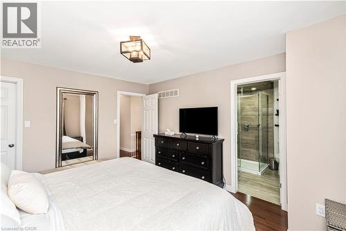 Bedroom featuring a closet, dark wood finished floors, and ensuite bath - 311 Highway 8 Unit# 12, Stoney Creek, ON - Indoor Photo Showing Bedroom