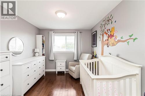 Bedroom with a nursery area and dark wood-type flooring - 311 Highway 8 Unit# 12, Stoney Creek, ON - Indoor Photo Showing Bedroom