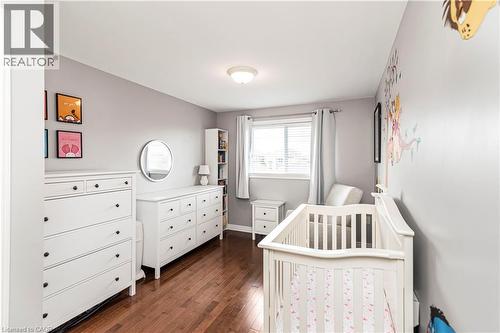 Bedroom with a crib and dark wood finished floors - 311 Highway 8 Unit# 12, Stoney Creek, ON - Indoor Photo Showing Bedroom