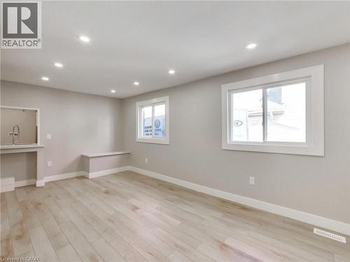 Spacious room featuring light wood flooring, recessed lighting, and two windows - 229 Parkdale Avenue N, Hamilton, ON 