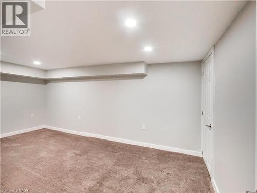 This room features soft brown carpeting, light grey walls, and recessed lighting - 229 Parkdale Avenue N, Hamilton, ON 