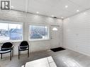This space features light-toned flooring and white walls, with one wall showcasing a shiplap design and another with a stacked stone appearance - 229 Parkdale Avenue N, Hamilton, ON 