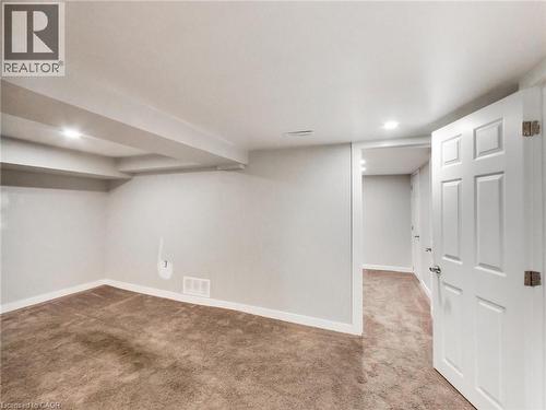 This room features neutral-toned carpet, light gray walls, and white trim - 229 Parkdale Avenue N, Hamilton, ON 