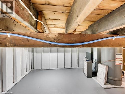 Basement with exposed wooden beams, white painted paneling, and gray flooring - 229 Parkdale Avenue N, Hamilton, ON 
