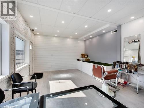 The interior space features light-toned flooring, white shiplap walls, and recessed lighting in the ceiling - 229 Parkdale Avenue N, Hamilton, ON 